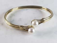 "A WONDERFUL WOMENS 14k GOLD PEARL & DIAMOND BANGLE BRACELET THAT WEIGHS 12.9g AND MEASURES ABOUT 8 1/2\" IN CIRCUMFERENCE. BRACELET IS MARKED 14K. THERE ARE ABOUT .14cts OF DIAMONDS. NOT SURE IF THE PEARLS ARE REAL OR NOT. PEARLS DID NOT FEEL GRITTY TO THE TEETH. ANY OTHER QUESTIONS PLEASE ASK. BE SURE TO CHECK OUT SOME OF MY OTHER GREAT ITEMS UP FOR SALE. THANK YOU." Classic Yellow Gold Pearl Bangle Bracelet, Elegant 14k Gold Stamped Bangle, Elegant 14k Stamped Round Bangle, Elegant 14k Stamped Bangle, Elegant 14k Stamped Anniversary Bracelets, Fine Jewelry Yellow Gold Pearl Bangle Bracelet, Elegant Round Gold Bracelet Stamped 14k, 14k Gold Pearl Bracelet, Elegant 14k Stamped Gold Bracelet