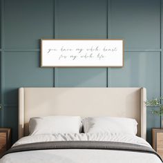 a bedroom with a bed, nightstands and a framed quote on the wall above it