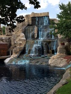 a large waterfall in the middle of a pond