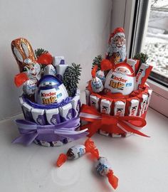 two baskets filled with candy sitting on top of a window sill next to a christmas tree