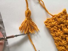 someone is crocheting the ends of two pieces of fabric with scissors and yarn