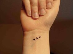 a woman's wrist tattoo with two birds on the left side of her arm