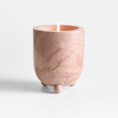 a pink marbled candle holder with a small wooden ball on the bottom and a white background