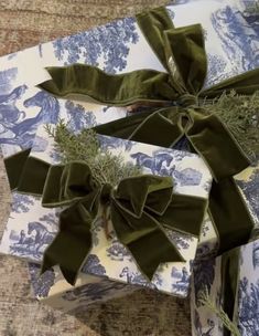 two wrapped presents with green bows on them