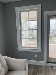 an empty living room with two windows in it