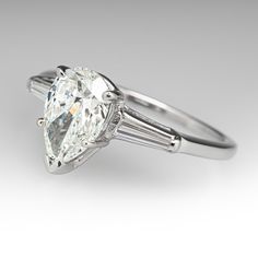 an oval cut diamond ring with baguettes on the sides and tapered shoulders