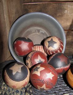 some old baseballs are sitting in a bucket on the floor next to a wooden bowl