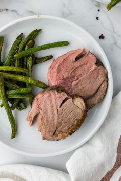 a white plate topped with meat and green beans