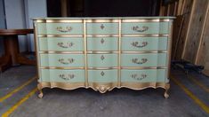 an antique dresser with gold trim and drawers