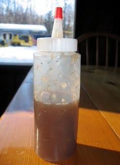 a plastic bottle filled with liquid sitting on top of a wooden table