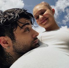 a man and woman looking at each other while they are cuddling in the sky