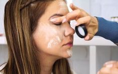 a woman getting her make - up done at home