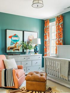 a baby's room with blue walls and orange curtains