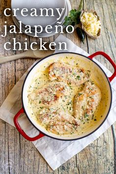 creamy jalapeno chicken in a red skillet on top of a wooden table