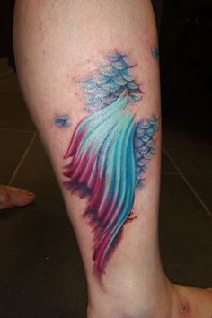 a colorful tattoo on the leg of a person