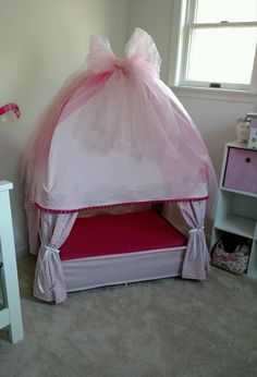 a child's bedroom with a bed made out of a pink princess castle tent