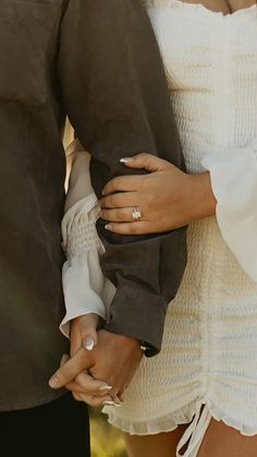 a close up of two people holding each other's hands while standing next to each other