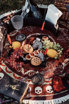 a table topped with lots of different types of food and drinks on top of a blanket