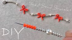 someone is making beaded bracelets with red beads and silver wire on the end