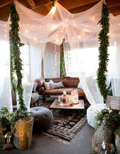 a living room filled with lots of furniture and lights hanging from the ceiling above it