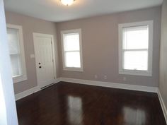 an empty living room with hard wood flooring and white trim on the walls,