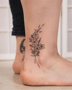 a woman's foot with a small flower tattoo on the left side of her ankle