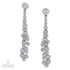 A staple in any jewelry box, these earrings are a contemporary interpretation of the classic diamond drop earrings. What we love most is the abstract configuration of the gemstones, meant to mimic the bubbling cascade of a waterfall. Each of the 44 white round brilliant diamonds is carefully bezel-set with white gold in an explosion of effervescent sparkle. The result is a beautiful scintillation of calibrated diamonds that come alive as the swivel catches the light when worn. Additionally, the length of these classic drop earrings with a modern twist is universal - elegantly thin to not overwhelm any face, and with just the right length to elongate the neck without overpowering. This little black dress with drop earrings should be a part of every contemporary wardrobe. The diamonds are eq Fine Jewelry Diamond White Drop Earrings, Exquisite Diamond White Drop Earrings, 14k Gold White Diamond Earrings, Fine Jewelry, Diamond White Earrings For Celebration, Fine Jewelry, Fine Jewelry Diamond-cut Earrings For Evening, White Gold Drop Earrings, Contemporary Wardrobe, Jewelry Diamond, Diamond Drop Earrings