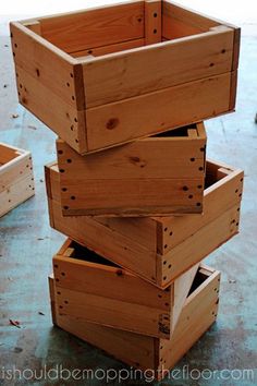 four wooden boxes stacked on top of each other in the middle of a floored area