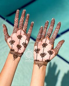 two hands with henna designs on them