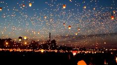 many lanterns are flying in the sky at night