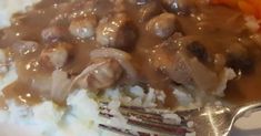 a white plate topped with rice and meat covered in gravy