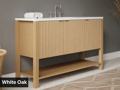 a bathroom vanity with two sinks and towels on the counter top next to a wicker basket