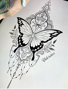 a drawing of a butterfly on top of a piece of paper next to a pen