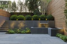 an outdoor garden with steps and plants on the sides, surrounded by wooden slatted walls