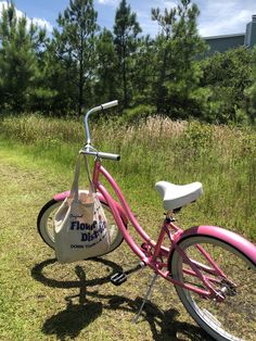 a pink bicycle parked on top of a grass covered field