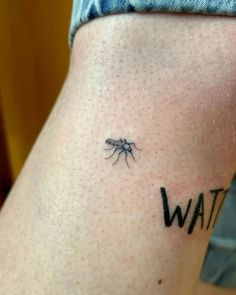 a small tattoo on the back of a woman's leg that says wait and a mosquito