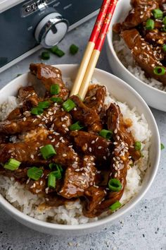 two white bowls filled with rice and beef