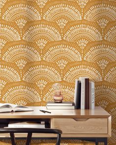 a desk with books on it next to a wallpaper