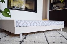 a white bed frame sitting on top of a rug