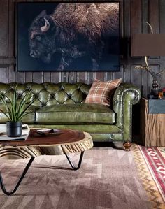 a living room filled with furniture and a bison painting on the wall above it's head