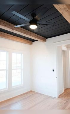 an empty room with wood flooring and ceiling fan in the middle of the room