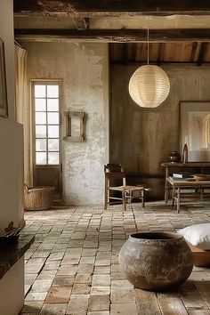 a large room with stone flooring and wooden ceiling lights hanging from the rafters