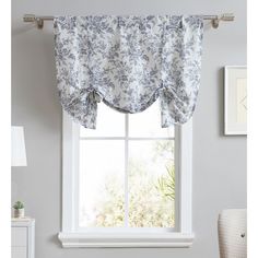 a window with a blue and white flowered valance