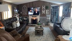 a living room filled with furniture and a flat screen tv mounted on the wall above a fireplace