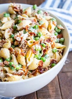 a white bowl filled with pasta and peas