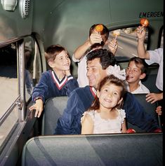 a group of people riding on the back of a bus with food in their hands