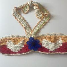 a crocheted headband with flowers on the side and two ties attached to it