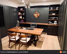 a home office with built - in shelving, desk and chair set up for two