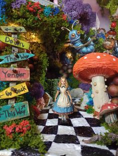 a doll is standing in the middle of a garden with mushrooms and other things on display