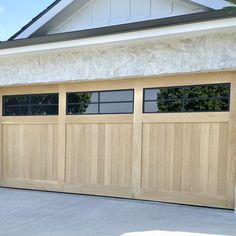 a wooden garage door in front of a white house